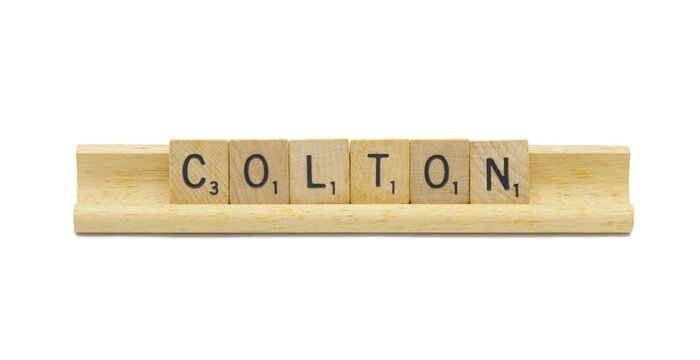 Miami, FL 4-18-24 popular baby boy first name of COLTON made with square wooden tile English alphabet letters with natural color and grain on a wood rack holder isolated on white background