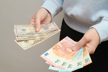Exchange US dollar or American dollars (USD) for EUR money. Woman counts banknotes. Woman hands counting money American dollars and euro. A lot of money in women's hands.