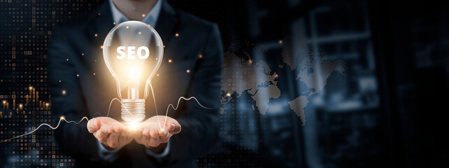 SEO: Search Engine Optimization. Hands of Businessman Holding Light Bulb and SEO Icon with Data...