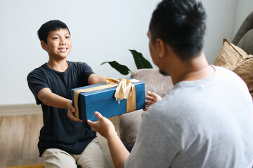 Young Preteen Boy Giving Present to His Dad on Father's Day Celebration 