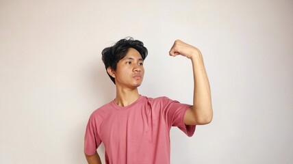 Handsome young Asian man posing showing his brave muscles on an isolated white background