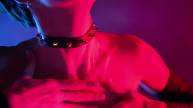Sexy woman in bdsm leather wear dances moves in smoky neon light. Erotic hot fetish costume, mistress in dark studio. Dancer in night club.
