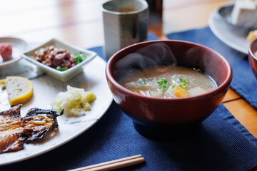Japanese breakfast includes grilled fish, miso soup, tofu,  Japanese pickled vegetables, and...