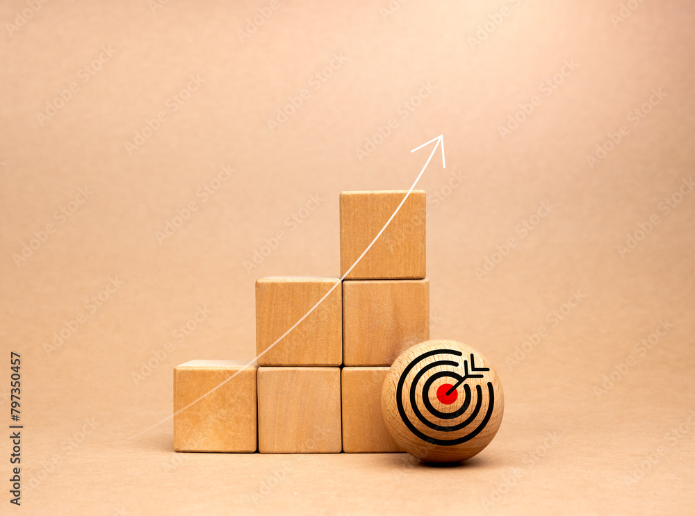 Poster target icon on wood ball near wooden cube blocks bar graph chart steps with rise up arrows on beige 