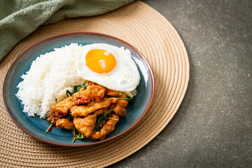 stir-fried fried fish with basil and fried egg topped on rice