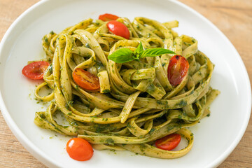 fettuccine spaghetti pasta with pesto sauce and tomatoes