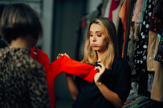 Woman Disliking the Blazer Presented to her by the Salesperson. Client in a fashion store having a negative shopping experience 
