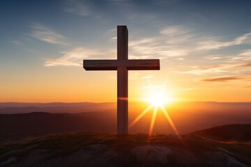 a cross on a hill with the sun in the background