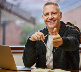 Portrait, senior man and laptop with thumbs up for remote work, agreement and schedule planning. Mature male therapist, home and emoji for yes with online counseling, telehealth and home on internet