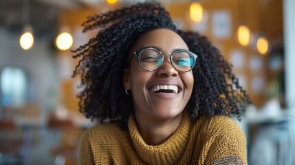 With a carefree spirit, a person's hearty laugh is accentuated by trendy eyewear and a vibrant mustard sweater in a relaxed setting.