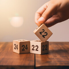Wooden cubes with numbers 2022 and female hand on the table. Business concept.