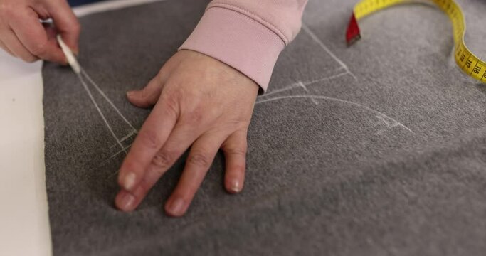 Seamstress with chalk for taking measurements on fabric