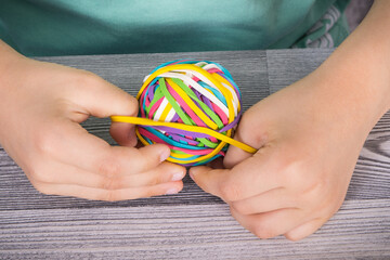 Preschooler hands playing with rubber bands or erasers. Development of kids motor skills,...