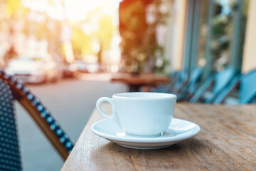 white single cup of coffee on table in street cafe on sunny day