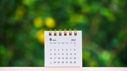 June 2024 month desk calendar on a table with nature background