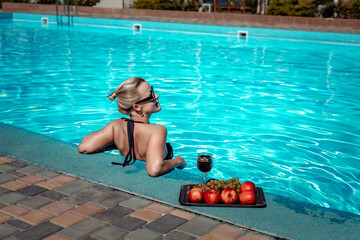 Bikini-clad woman enjoys poolside relaxation. Poolside ambiance. Capturing woman's relaxed time...