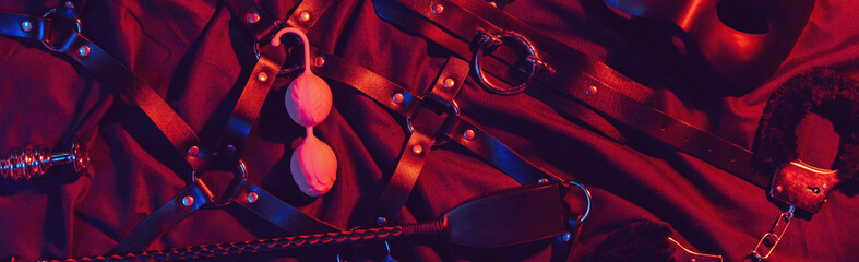 set of BDSM sex toys with handcuffs, whip flogger, butt anal plug for submission and domination on...
