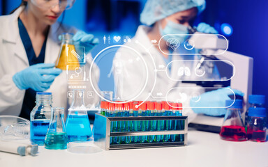Fototapeta premium Young scientists conducting research investigations in a medical laboratory, a researcher in the foreground is using a microscope in laboratory