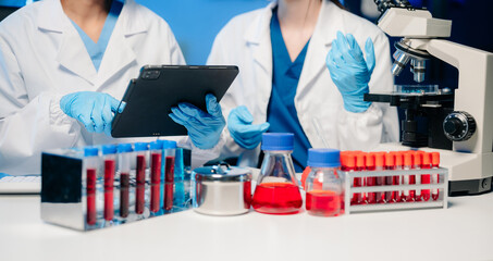 Modern Medical Research Laboratory Portrait of Two Scientists Working, Using Digital Tablet,...