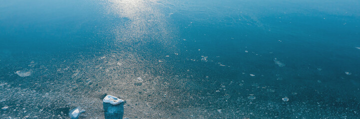 Top view of the freezing sea. Winter aerial view of ice floes in blue sea water. Glare on the...