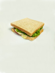 A nutritious whole wheat sandwich featuring layers of fresh ingredients. Soft whole wheat bread encases slices of meat, mozarella, lettuce, and fresh tomatoes. Perfect for a healthy meal on the go.