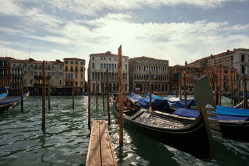 Fototapeta na wymiar A serene view of gondolas moored along a sun-kissed canal in Venice, Italy.
