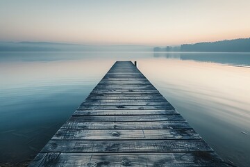 Overlooking a tranquil lake, a solitary wooden pier extends gracefully into the water, its...