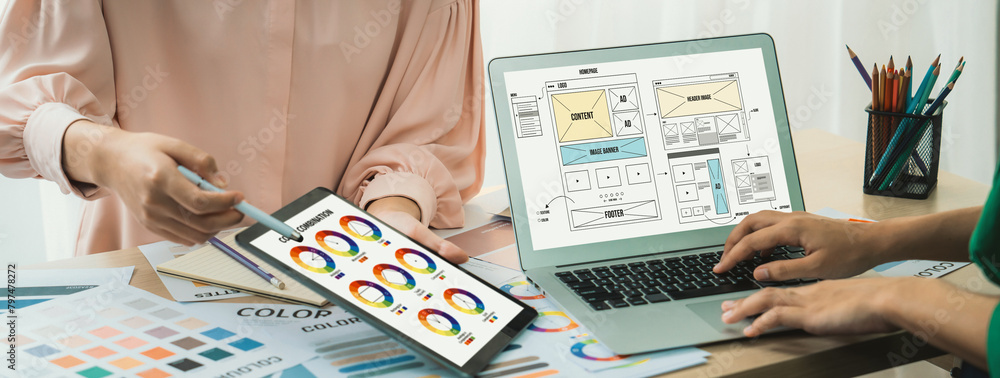 Poster cropped image of interior designer presents color from color swatches while laptop displayed website