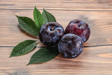 Raw purple plums heap with leaves - 797482226