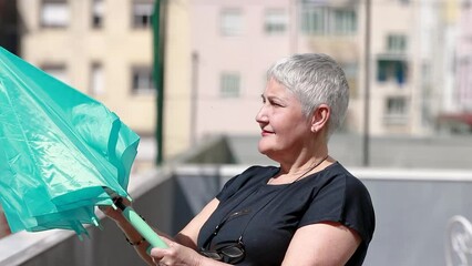 senior woman opening umbrella