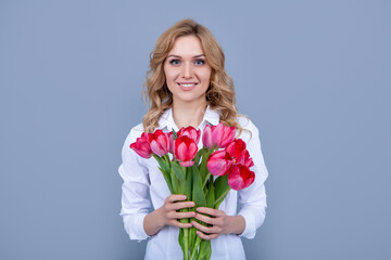 cheerful girl with spring tulip flowers on grey background