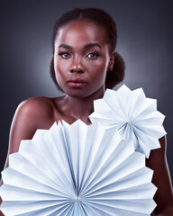 Black woman, portrait and origami fans in studio, cosmetics and oriental beauty on dark background....
