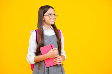 Back to school. Teenager schoolgirl with book ready to learn. School girl children on isolated yellow studio background.