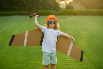 Kid playing with toy airplane and dreaming future. Happy boy pilot play with airplane outdoors.