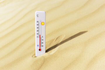 Hot summer day. Celsius scale thermometer in the sand. Ambient temperature plus 9 degrees