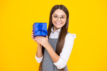 Portrait of teenager child girl 12, 13, 14, years old holding Christmas gift box. Teen giving birthday gift.