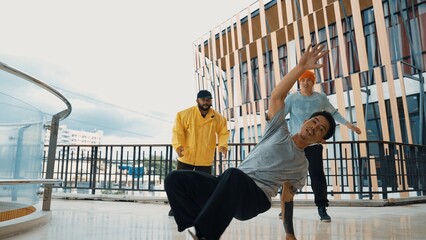 Hip hop team dance break dance while multicultural friend surrounded and clapping hands to cheer or...