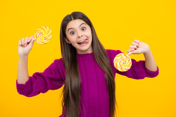 Teenager girl eating sugar lollypop. Candy and sweets for kids. Child eat lollipop popsicle over yellow isolated background. Yummy caramel, candy shop, funny face.