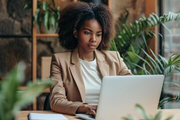 Black woman using laptop to edit resume CV - Powered by Adobe