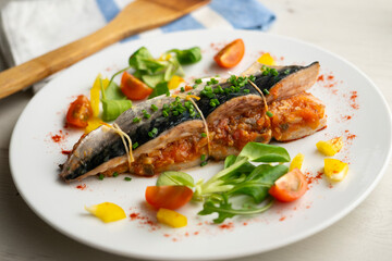 Oven-cooked mackerel stuffed with tomato sauce and vegetables.