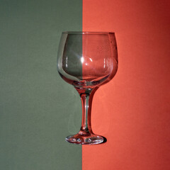 Glass of wine on an aesthetic green and orange background creative concept with copy space. 