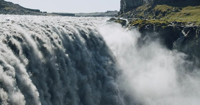 massive and epic waterfall dettifoss riging water volume falling down over the edge 4K 