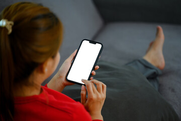 Young woman sitting on couch holding mobile phone with blank screen, Close up - 797550417