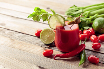 Bloody Mary cocktail garnished with gherkin, olive, lime, and celery.