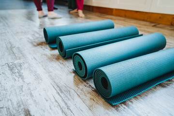 Rectangular electric blue and magenta yoga mats stacked on wooden flooring