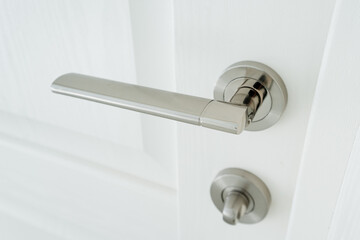 Chrome door handle, home hardware, lock on white door.