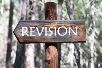 Revision inscription, inscription on the wooden signpost against the background of the forest