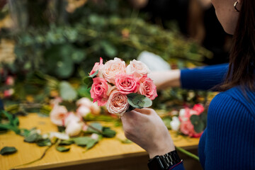The woman is happily holding a bouquet of pink garden roses