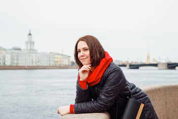 looking away young pensive daydreaming happy female woman on city embankment of St. Petersburg....