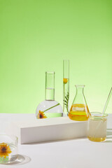 Over the green background, types of laboratory glassware containing liquid extracted from Calendula...